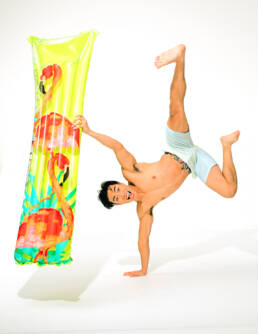 Young asian man with float mat on a white set by commercial studio photographer Randy Schwartz